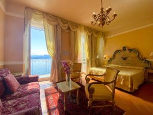 卡尼洛瑞维拉Hotel Cannero的一间卧室配有一张床、一张沙发和一个窗口