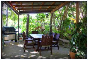 汤斯维尔珊瑚山林小屋住宿加早餐旅馆的一个带桌椅和烧烤架的庭院