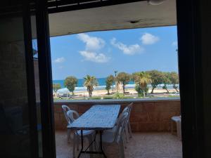 阿卡First Sea Line Apartment, Acre - amazing coastal view in heart of Akko的海滩景阳台配有桌椅