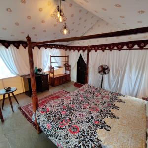 浦那Exotic Stay - a unique experience的一间卧室配有一张带花卉床罩的天蓬床