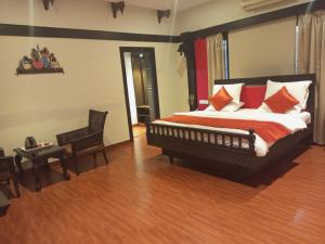马杜赖Mount Retreat Resorts - Madurai的一间卧室配有一张带红色和白色枕头的大床