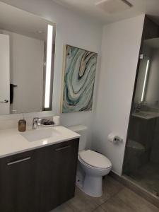 迈阿密Lovely Condo Unit的浴室配有卫生间、盥洗盆和淋浴。