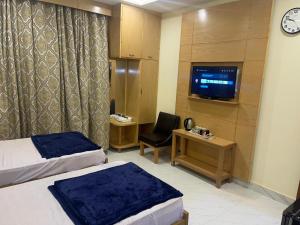 LiāquatpurMughal E Azam Hotel的酒店客房设有两张床和电视。