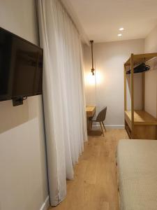 阿基欧斯尼古拉斯9 Muses Apartments的卧室配有白色窗帘、一张床和一张书桌