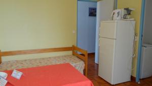 萨戈内Residence Funtanella的小房间设有白色冰箱和桌子