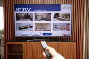 墨西哥城查普尔特佩克格兰德费斯塔美国酒店&度假村的电视机前有遥控器的人