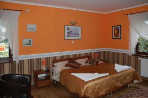 尼萨瑞多斯餐厅酒店的一间卧室配有一张橙色墙壁的床