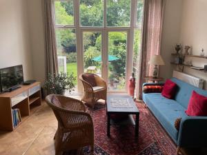 伦敦Spacious Holiday Home!的客厅设有蓝色的沙发和大窗户