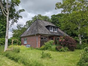 HumptrupCharmantes Ferienhaus in Nordfriesland的旧砖房,坐在田野里