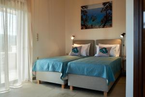 LoutrákionVilla Olive Valley的一间卧室设有两张床和窗户。