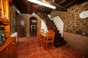 San FelizCasa Rural El Corquieu de la Cava的一间带桌椅和楼梯的用餐室