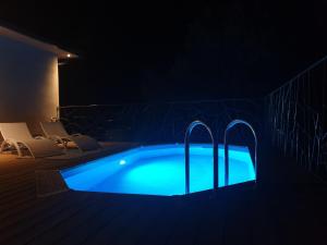 MoltifaoDomaine U Filanciu - Maison Chiara avec piscine - Centre Corse的夜间游泳池,灯光蓝色