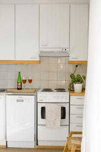 纳坦利Lillmåsen Naantali - atmospheric and very comfy studio的厨房配有白色橱柜和白色炉灶烤箱。