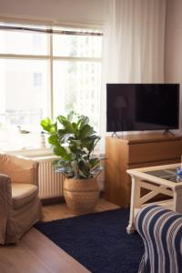 纳坦利Lillmåsen Naantali - atmospheric and very comfy studio的一间配有电视和盆栽植物的客厅
