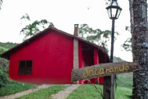 康塞高伊比蒂波卡Sítio das Hortênsias Chalés的前面有标志的红色谷仓