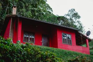 康塞高伊比蒂波卡Sítio das Hortênsias Chalés的山边的红色房子
