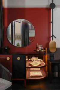 纽卡斯尔QT Newcastle的一间用镜子装饰的红色墙壁用餐室