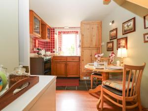DunsThe Coach House的带木桌的厨房和带水槽的厨房
