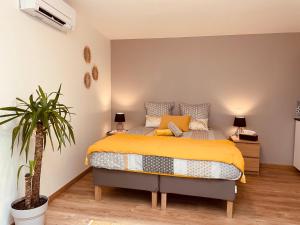 圣艾米隆Maison De La Tour的一间卧室配有一张床和盆栽植物