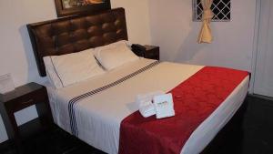 波哥大Casa Hotel Victoria的一间卧室配有一张带红色毯子的大床