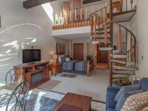 杜兰戈Tamarron Lodge Loft 314的带沙发和电视的客厅以及楼梯。