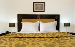 伊夫兰伊夫兰法拉旅馆的一间卧室配有一张大床和两盏灯