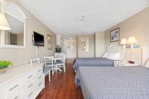 默特尔比奇Driftwood 51009的酒店客房带两张床和一张桌子以及椅子。