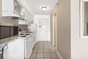 默特尔比奇Driftwood 51009的厨房配有白色家电,铺有瓷砖地板。