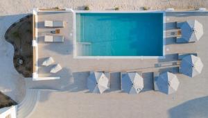 米科利维亚Naxos Earth Suites的享有带遮阳伞的游泳池的顶部景致