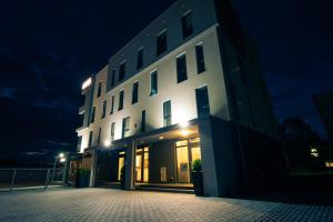 特尔纳瓦有家公寓式酒店的一座白色的大建筑,晚上有灯光