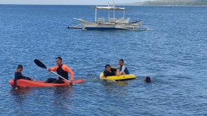 ZamboanguitaShenanigans Glamping Resort的一群人划着皮艇,在水中划着小船