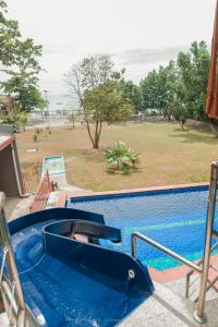 ZamboanguitaShenanigans Glamping Resort的毗邻度假酒店的带滑梯的游泳池