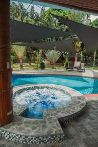 ZamboanguitaShenanigans Glamping Resort的一个带桌子和遮阳伞的游泳池
