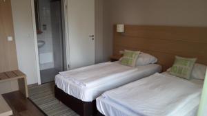 费尔登德尔海德克鲁格酒店的小型客房的两张床,配有镜子