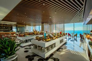 岘港Le Sands Oceanfront Danang Hotel的一间设有桌椅的海洋餐厅