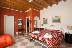 圣费利切德尔贝纳科Barchi Resort - Apartments & Suites的一间设有床铺的卧室,位于一个拥有橙色墙壁的房间