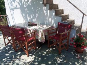 AkamatraTraditional house in Akamatra square的一张桌子、两把椅子和一张桌子及一张桌布