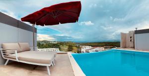 TutongThe Lanes Hotel的阳台的椅子和遮阳伞,带游泳池