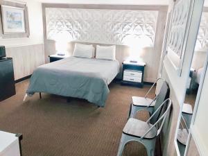 希塞德高地Buoy 16 Motel by the Beach的一间卧室配有一张床、两张桌子和两盏灯。