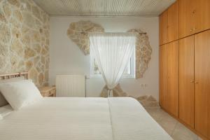 约阿尼纳Bungalow Episkopiko的卧室配有白色的床和窗户。