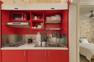约阿尼纳Bungalow Episkopiko的一间带红色橱柜和水槽的厨房