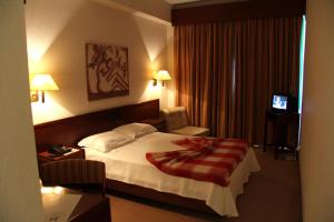 阿加尼尔阿甘尼尔酒店的酒店客房的床铺上铺有红色毯子