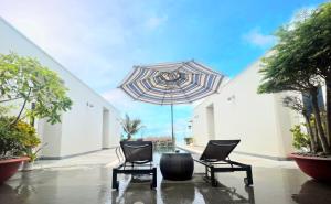 隆海Oceanami 5 Bedrooms Private Pool的庭院里配有两把椅子和一把遮阳伞