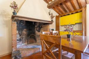 里奥托尔托Appartamento Cerboli的一间带桌子和壁炉的用餐室