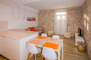 赫罗纳Apartamento histórico en el Barri Vell Girona的厨房以及带桌椅的起居室。