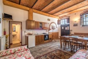 卡斯蒂廖恩菲博基Poggio Primo - Bilocale Vermiglio的厨房配有木制橱柜和桌椅