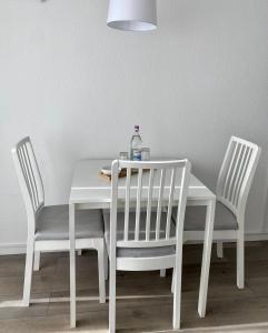 戈斯拉尔Seeblickapp. „Eure Auszeit“的一张带两把椅子的白色桌子和一瓶