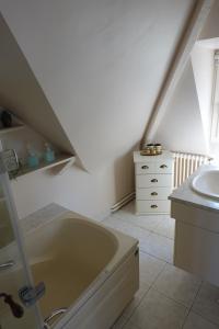 图尔热维尔Villa sur la plage的浴室配有盥洗盆和浴缸。