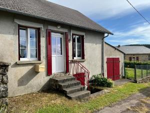 ArleufMaison au coeur du Morvan的一间设有红色门和楼梯的小房子