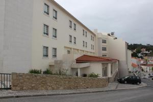 阿尔科巴萨圣玛丽亚酒店的前面有一辆汽车停放的白色建筑
